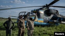 Украинские военные у ударного вертолета Ми-24 в Днепропетровской области. Июнь 2023.