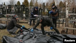 Похороны погибших жителей на кладбище в городе Буча в Киевской области.