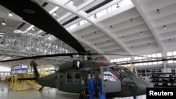 Работники завода PZL Mielec рядом с первым вертолетом Black Hawk S-70i, произведенным за пределами США в Мелеце, Польша. 11 марта 2010 года.